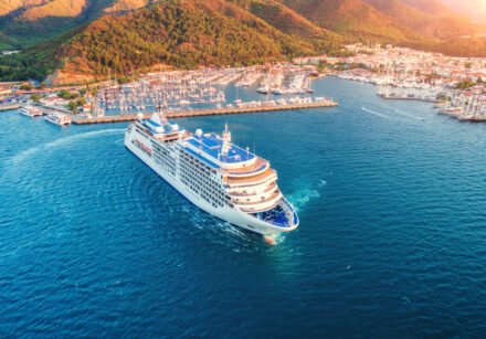 Cruise ship at harbor. Aerial view of beautiful large white ship at sunset. Landscape with boats, mountains, sea, blue sky. Top view of yacht. Luxury cruise. Floating liner in Europe. Travel. Resort